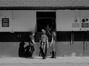 Three children in riding gear stand by a stable door. jigsaw puzzle
