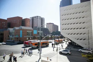 people walking on sidewalk near white and orange bus during daytime jigsaw puzzle