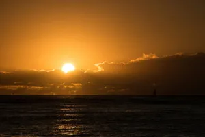 The sun is setting over the ocean on a cloudy day jigsaw puzzle