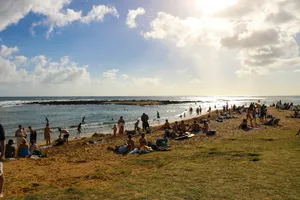 A group of people standing on top of a sandy beach jigsaw puzzle