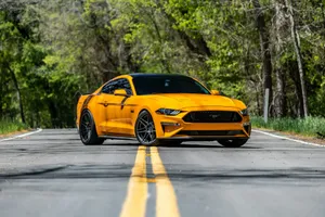 a yellow ford mustang parked on the side of the road jigsaw puzzle