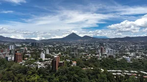 Panoramic city view with green hills and a prominent volcano. jigsaw puzzle