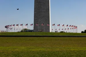 American flags encircle the washington monument under a clear sky. jigsaw puzzle