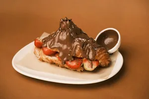 A piece of chocolate dessert on a plate with a spoon jigsaw puzzle