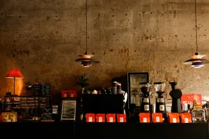 Coffee shop counter with grinders, bags, and rustic wall. jigsaw puzzle