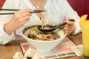 a woman eating a bowl of noodles with chopsticks jigsaw puzzle