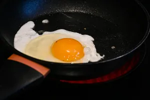 A fried egg in a frying pan on a stove jigsaw puzzle