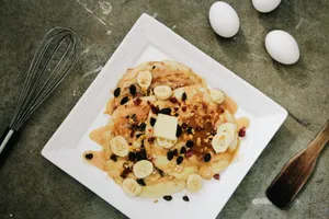 plate of pancake topped with sliced bananas and chocolate syrup jigsaw puzzle