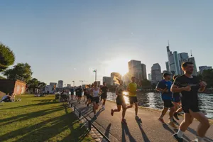 A group of people running down a street next to a river jigsaw puzzle