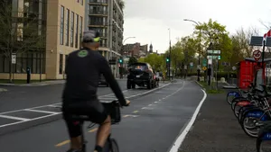 Cyclist rides on urban street with buildings and parked bicycles. jigsaw puzzle