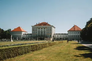 A large white building sitting next to a lush green field jigsaw puzzle