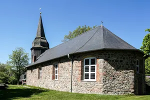 Historic stone church with a tall steeple under clear sky. jigsaw puzzle