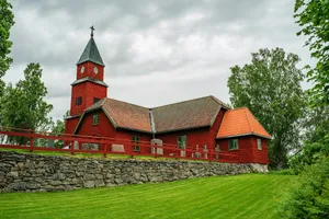 Historic red wooden church on a green hill. jigsaw puzzle