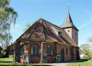 Historic brick church with a tall steeple and tiled roof. jigsaw puzzle