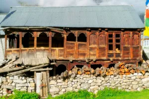 A wooden house stands behind a stone wall. jigsaw puzzle