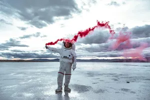 a man in a white space suit holding a red substance jigsaw puzzle