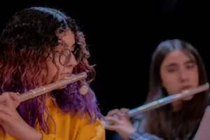 Two girls playing flutes in front of a black background. jigsaw puzzle