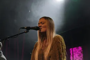 woman in brown knit sweater singing jigsaw puzzle