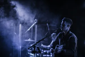 man playing acoustic guitar while singing on stage jigsaw puzzle