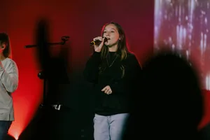 a woman standing in front of a microphone on a stage jigsaw puzzle