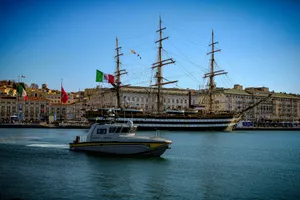A patrol boat sails past a large sailing ship. jigsaw puzzle