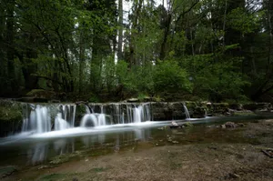 Tranquil waterfall in a lush forest captured with a long exposure technique. jigsaw puzzle