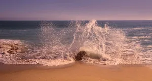 Captivating image of ocean waves crashing energetically onto a sandy shore during the day. jigsaw puzzle