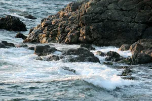 Waves crash onto the rocky shoreline, capturing nature's raw power and beauty. jigsaw puzzle