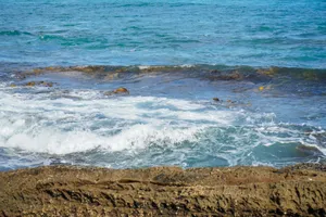 Peaceful ocean waves break over rocky seashore, capturing serene coastal beauty. jigsaw puzzle