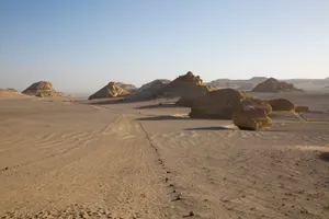 Expansive desert landscape featuring unique rock formations and a clear blue sky. jigsaw puzzle