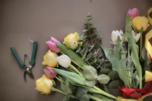 From above of bunch from various colorful flowers decorated with silk tapes placed on brown surface together with pruner illustrating floristry concept jigsaw puzzle