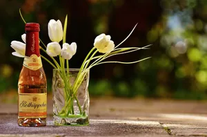 A beautiful arrangement featuring rosé wine and fresh white tulips on a sunny day. jigsaw puzzle