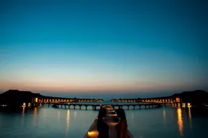 Captivating sunset over illuminated overwater villas offering a serene and luxurious ambiance. jigsaw puzzle