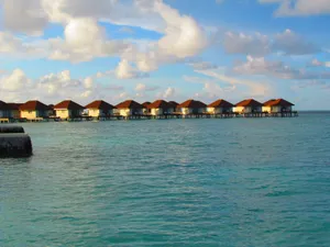 Scenic view of overwater bungalows in Maldives during sunset, showcasing turquoise waters and beautiful skies. jigsaw puzzle