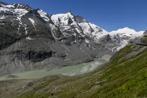 Stunning aerial view of snow-capped Alpine mountains with a serene lake in the valley. jigsaw puzzle