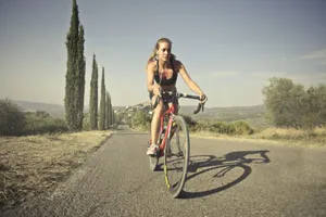 Woman cycling on a rural road, enjoying a sunny day and scenic landscape. jigsaw puzzle