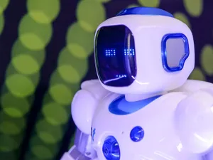 Close-up of a modern humanoid robot with glowing blue features on a green abstract background. jigsaw puzzle