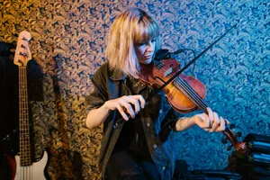 A woman elegantly plays the violin indoors, showcasing musical talent and passion. jigsaw puzzle