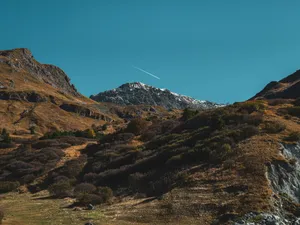 Mountain landscape with a clear blue sky and distant plane. jigsaw puzzle