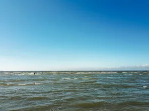 a body of water with a beach and blue sky jigsaw puzzle