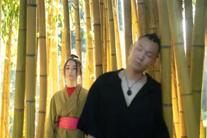 A serene portrait of a couple in traditional Japanese kimonos amidst sunlit bamboo stalks. jigsaw puzzle