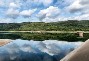 Serene landscape of Langelsheim with lush hills and mirrored sky on the dam. jigsaw puzzle