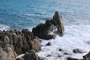 Dramatic sea waves crash against rugged rocks, showcasing nature's raw power. jigsaw puzzle