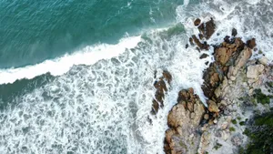 A stunning aerial shot of waves crashing against a rocky coastline, showcasing natural beauty. jigsaw puzzle