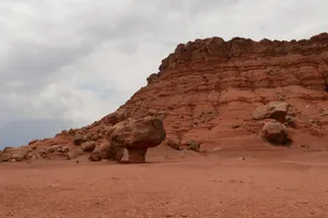 Explore the majestic red rock formations and arid desert landscape under a cloudy sky. jigsaw puzzle
