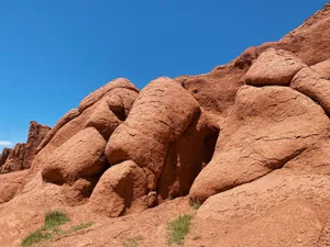 Striking red rock formations under a clear blue sky in a desert setting. jigsaw puzzle