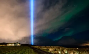 A striking blue beam from the Imagine Peace Tower illuminates the Icelandic night sky in a rural setting. jigsaw puzzle