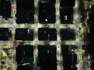 High-angle aerial shot of illuminated city streets and intersections at night. jigsaw puzzle