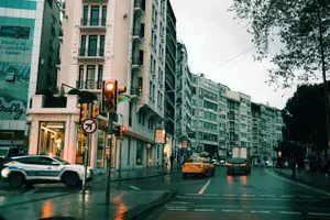 City scene with moving traffic, wet streets, and towering buildings at dusk in an urban area. jigsaw puzzle