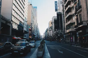 Street view of Buenos Aires bustling with traffic and surrounded by tall buildings under daylight. jigsaw puzzle